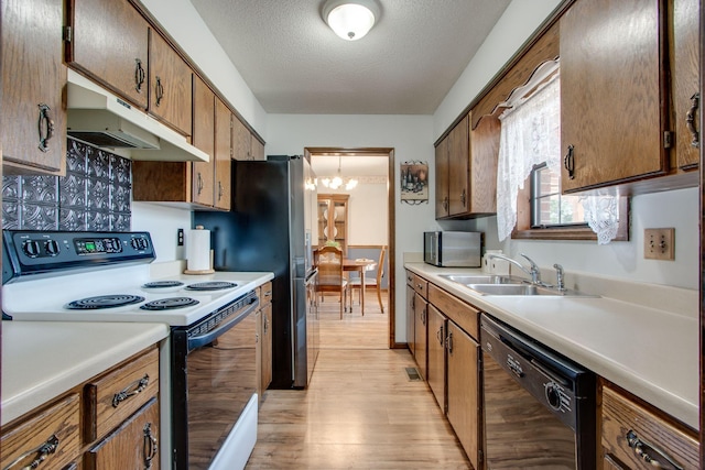 kitchen featuring sink, range with electric cooktop, black dishwasher, light hardwood / wood-style floors, and a textured ceiling