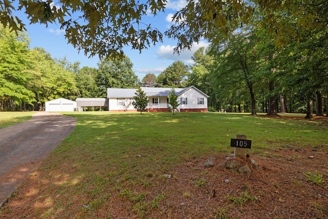 view of front of property with an outdoor structure, a garage, and a front yard