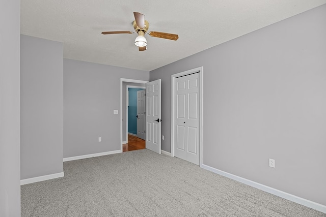 unfurnished bedroom featuring a closet, carpet floors, and ceiling fan