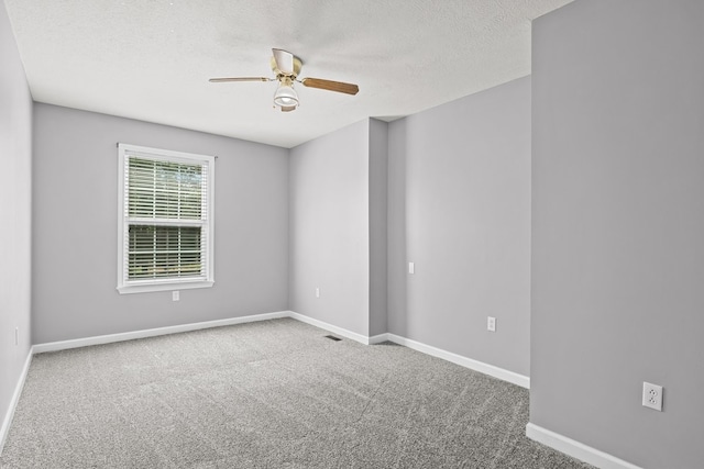 carpeted spare room with a textured ceiling and ceiling fan