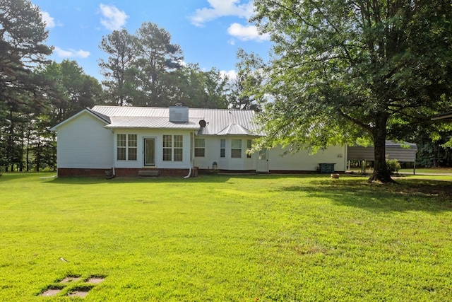 rear view of property with a lawn