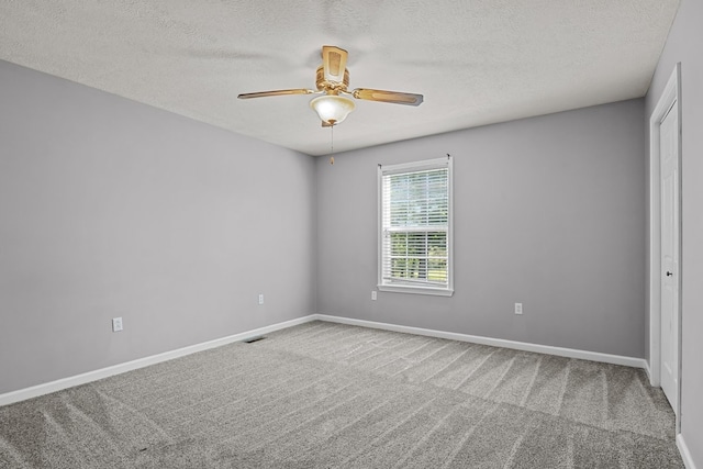 empty room with carpet flooring, a textured ceiling, and ceiling fan