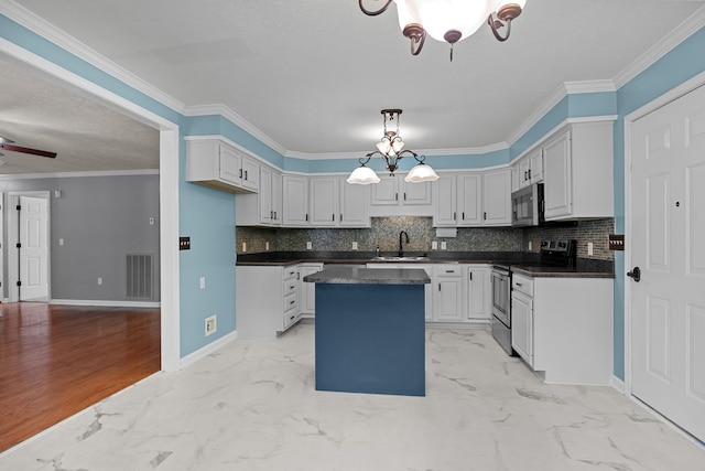 kitchen featuring appliances with stainless steel finishes, sink, decorative light fixtures, light tile patterned flooring, and ornamental molding