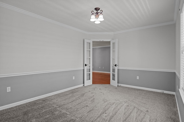 carpeted empty room with ornamental molding, french doors, and a chandelier