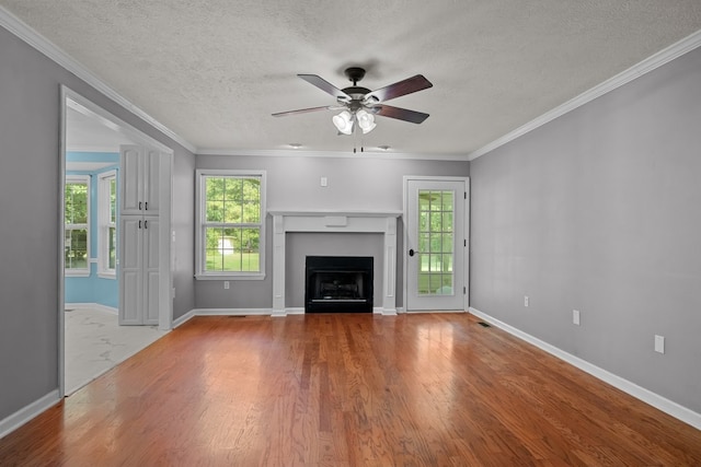 unfurnished living room featuring wood-type flooring, a textured ceiling, crown molding, and ceiling fan