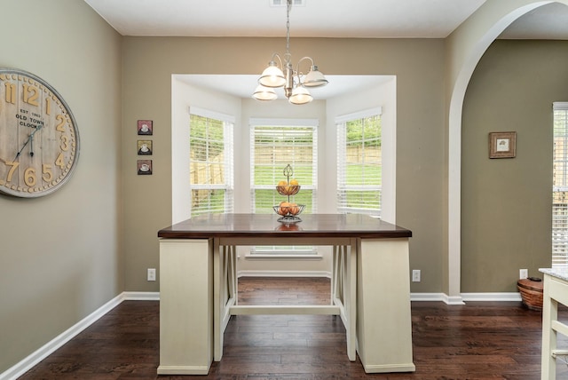 unfurnished dining area with dark hardwood / wood-style flooring and an inviting chandelier