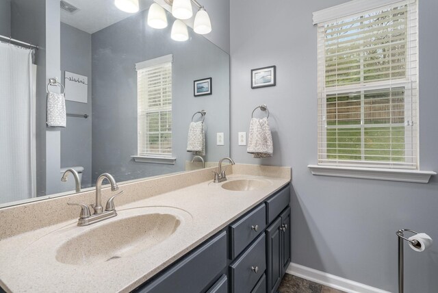 bathroom with a healthy amount of sunlight and double sink vanity