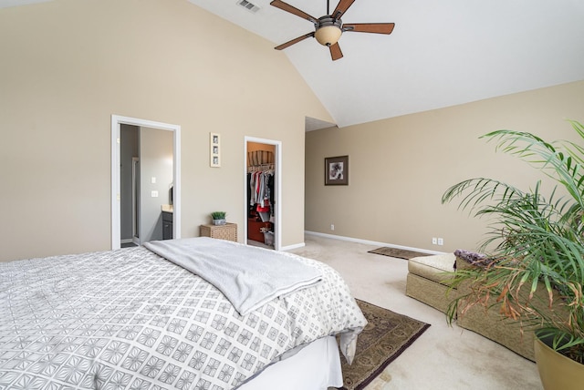 carpeted bedroom featuring ensuite bathroom, a walk in closet, high vaulted ceiling, a closet, and ceiling fan