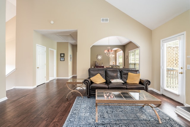 living room with dark hardwood / wood-style flooring, an inviting chandelier, and high vaulted ceiling