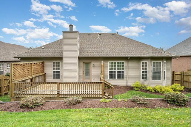 back of property featuring a wooden deck and a lawn