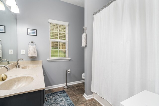 bathroom with double vanity, tile patterned flooring, and toilet