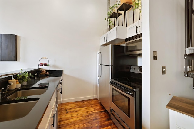 kitchen with stainless steel appliances, dark hardwood / wood-style floors, sink, and white cabinets