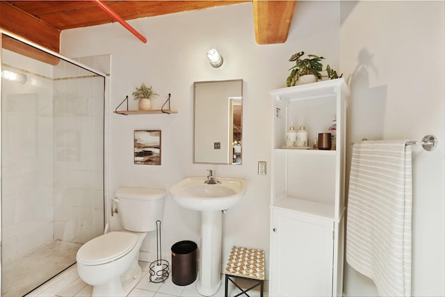 bathroom with tiled shower, tile patterned floors, toilet, and beam ceiling