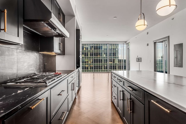 kitchen featuring a healthy amount of sunlight, light parquet floors, decorative backsplash, and wall chimney exhaust hood