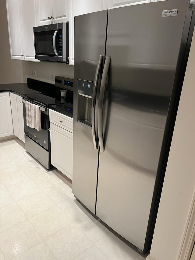 kitchen with white cabinetry, stainless steel appliances, and light tile patterned floors