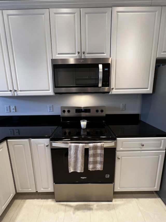 kitchen with white cabinetry, appliances with stainless steel finishes, and light tile patterned floors