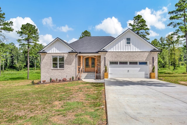 view of front of property with a garage, french doors, and a front lawn