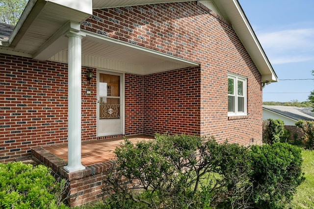 view of side of property with covered porch and brick siding