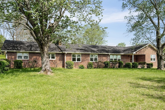 single story home featuring a front yard and brick siding