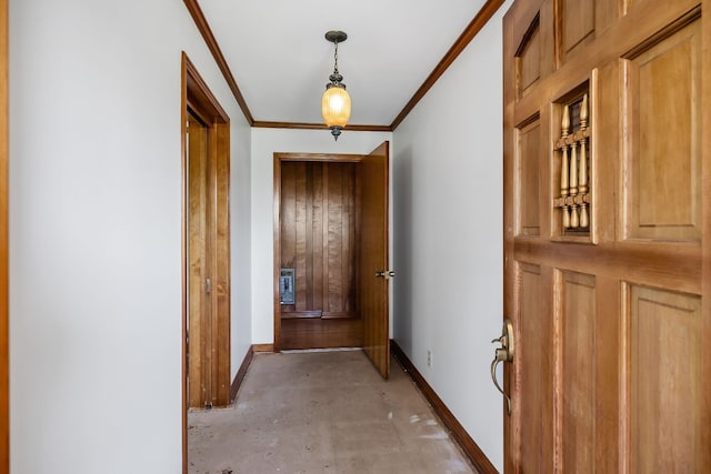 hallway featuring ornamental molding, concrete floors, and baseboards