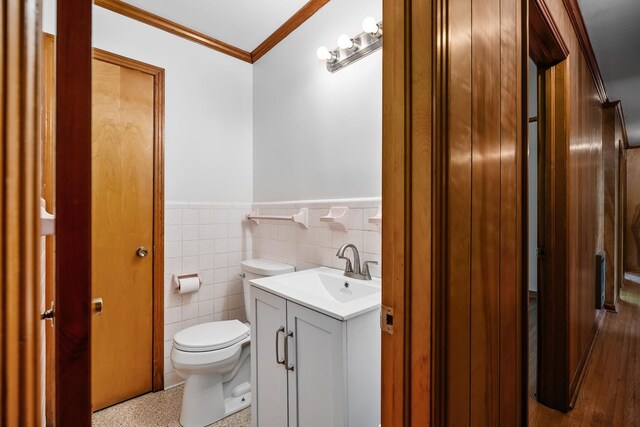 bathroom with tasteful backsplash, toilet, vanity, tile walls, and wood-type flooring