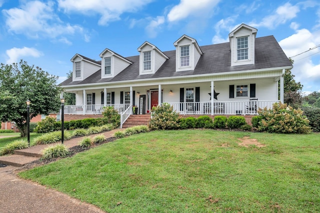 new england style home featuring covered porch and a front lawn