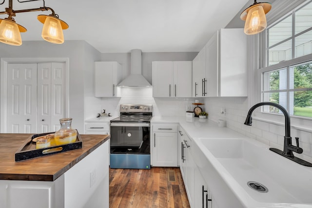 kitchen featuring wall chimney exhaust hood, tasteful backsplash, hanging light fixtures, stainless steel electric range, and sink