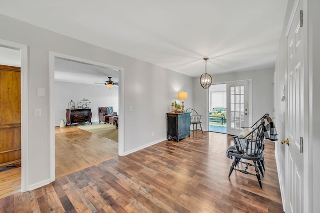 interior space with ceiling fan with notable chandelier, french doors, and wood-type flooring