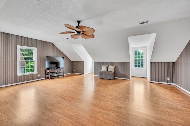 additional living space with light wood-type flooring and a textured ceiling