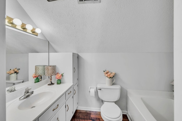 bathroom with toilet, vanity, hardwood / wood-style flooring, a textured ceiling, and lofted ceiling