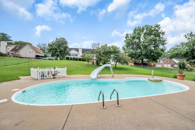 view of swimming pool with a water slide and a yard