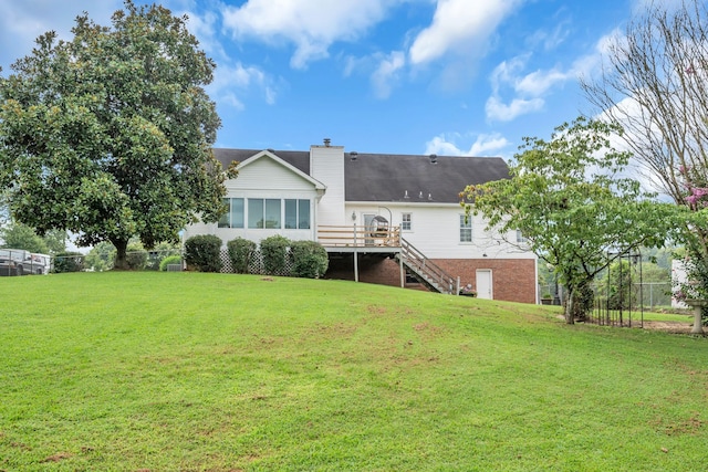 back of property featuring a yard and a deck