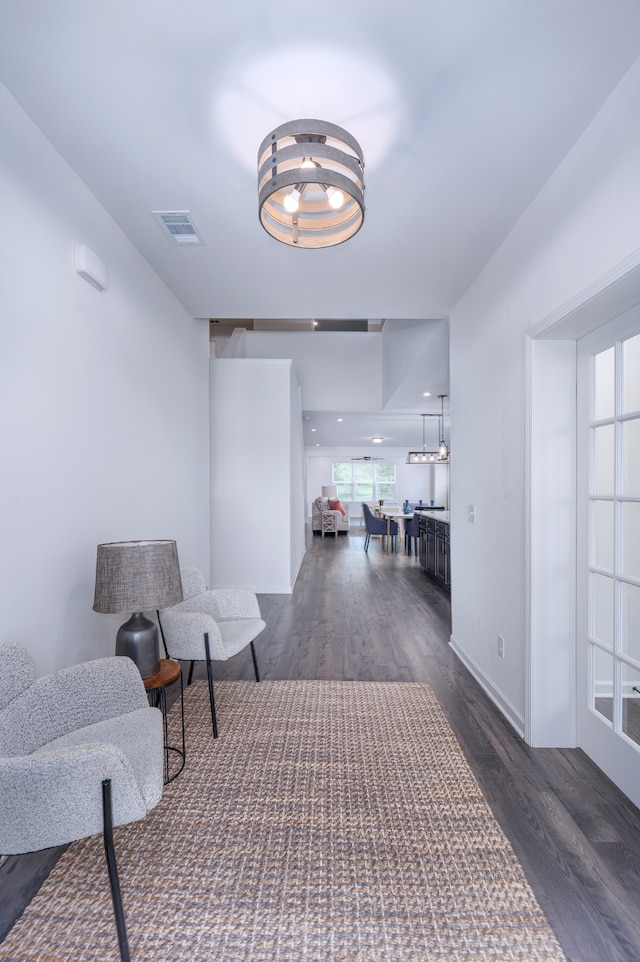 hallway with dark hardwood / wood-style flooring and a notable chandelier