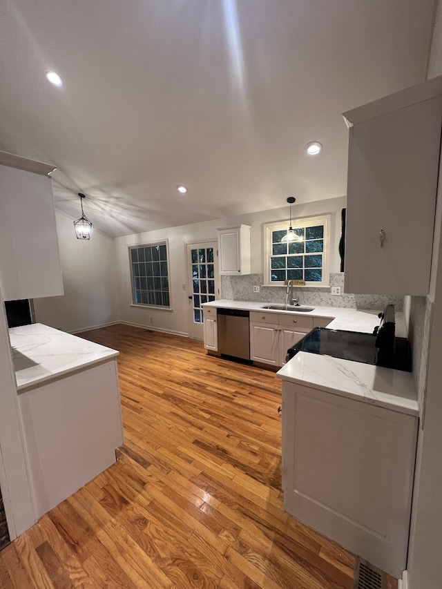 kitchen featuring sink, pendant lighting, light stone counters, light hardwood / wood-style floors, and dishwasher