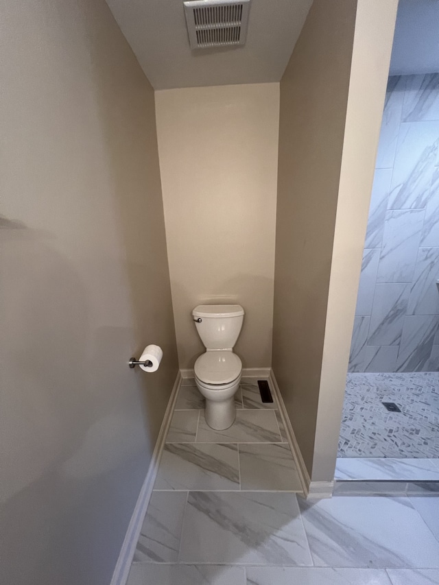 bathroom with toilet, tile patterned flooring, and a shower