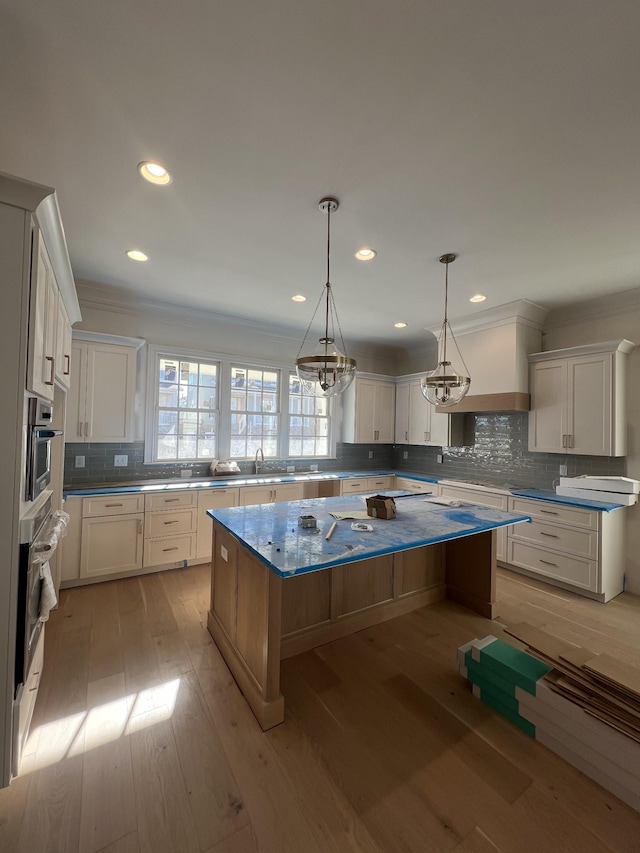 kitchen featuring white cabinets, a kitchen island, and light hardwood / wood-style floors