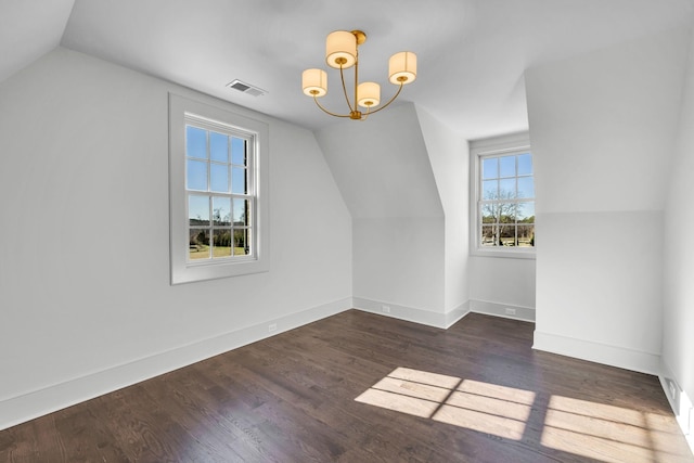 additional living space with vaulted ceiling, dark hardwood / wood-style floors, and a chandelier