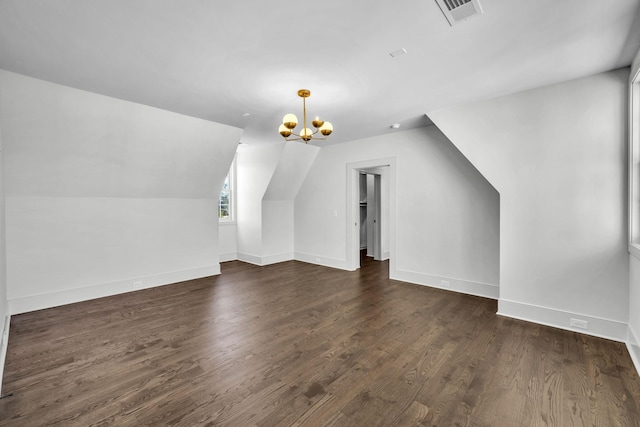 bonus room with dark hardwood / wood-style flooring, lofted ceiling, and an inviting chandelier