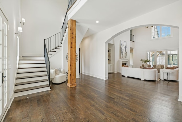 foyer entrance with a towering ceiling and dark hardwood / wood-style flooring