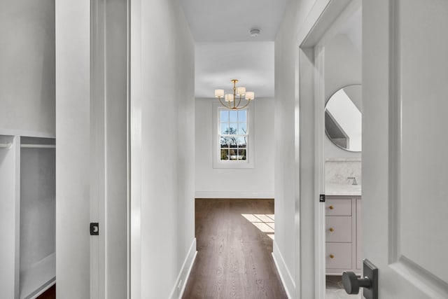 hallway featuring dark hardwood / wood-style floors and a chandelier