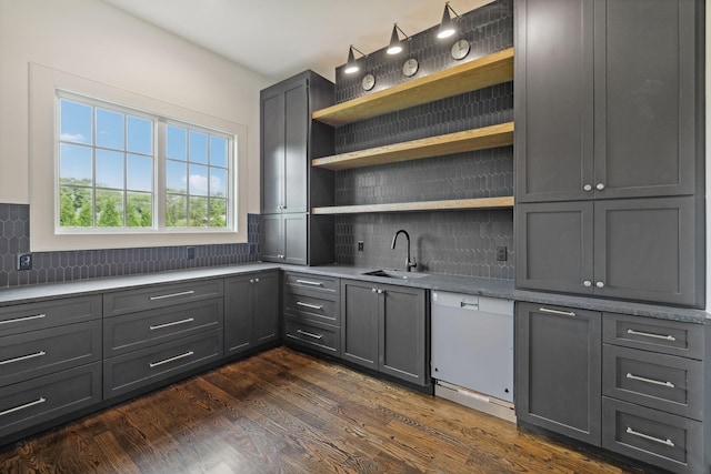 kitchen with sink, tasteful backsplash, dark hardwood / wood-style floors, white dishwasher, and gray cabinets