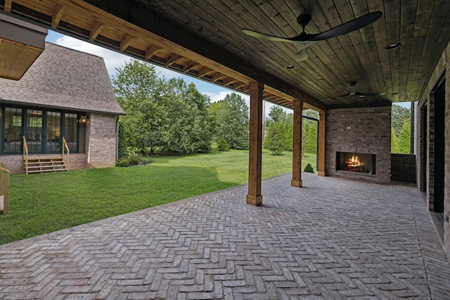 view of patio featuring an outdoor brick fireplace and ceiling fan