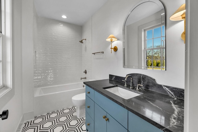 full bathroom featuring tiled shower / bath combo, vanity, tile patterned floors, and toilet