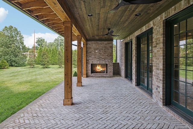 view of patio featuring an outdoor brick fireplace and ceiling fan