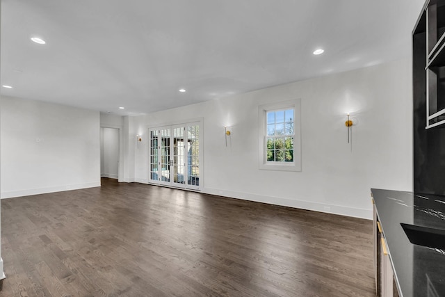 unfurnished living room featuring dark hardwood / wood-style floors and french doors