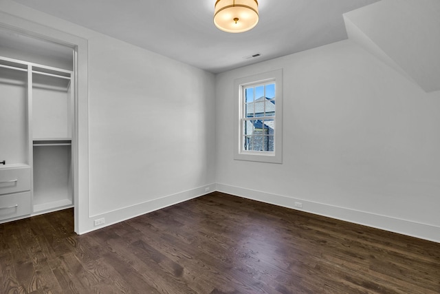 unfurnished bedroom featuring a closet and dark hardwood / wood-style floors