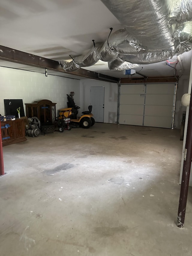 garage with concrete block wall and a garage door opener