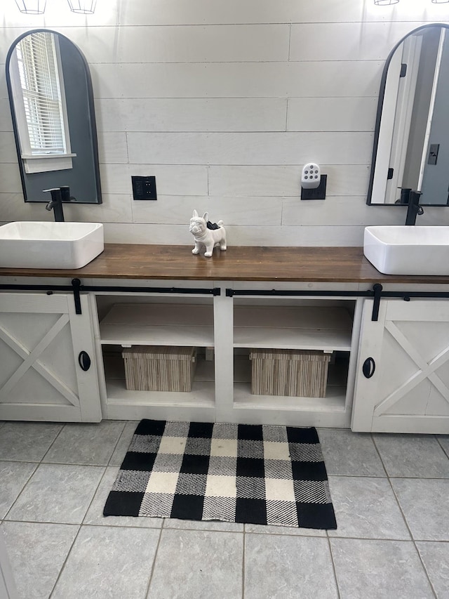 full bathroom featuring double vanity, tile patterned flooring, and a sink