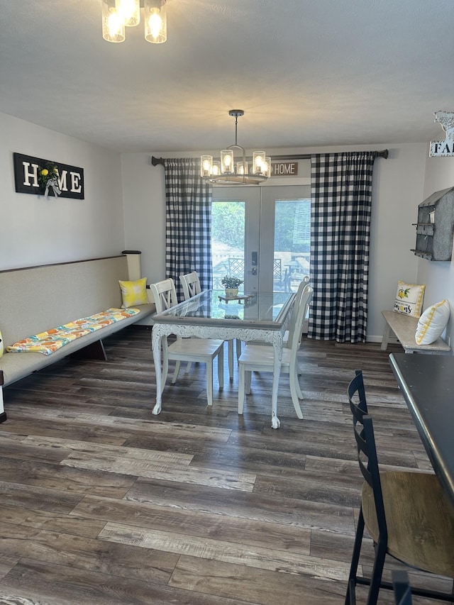 dining area featuring dark wood finished floors and an inviting chandelier