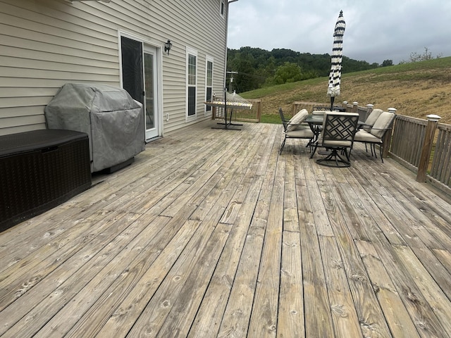 deck featuring a grill and outdoor dining area